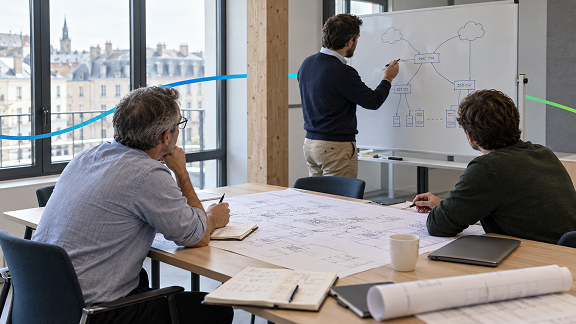 Network engineers collaborating on network architecture and infrastructure planning during a technical workshop.