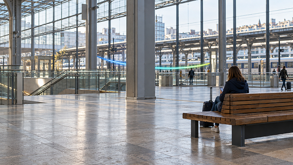 Passenger waiting in a modern train station, illustrating secure network access from public locations.